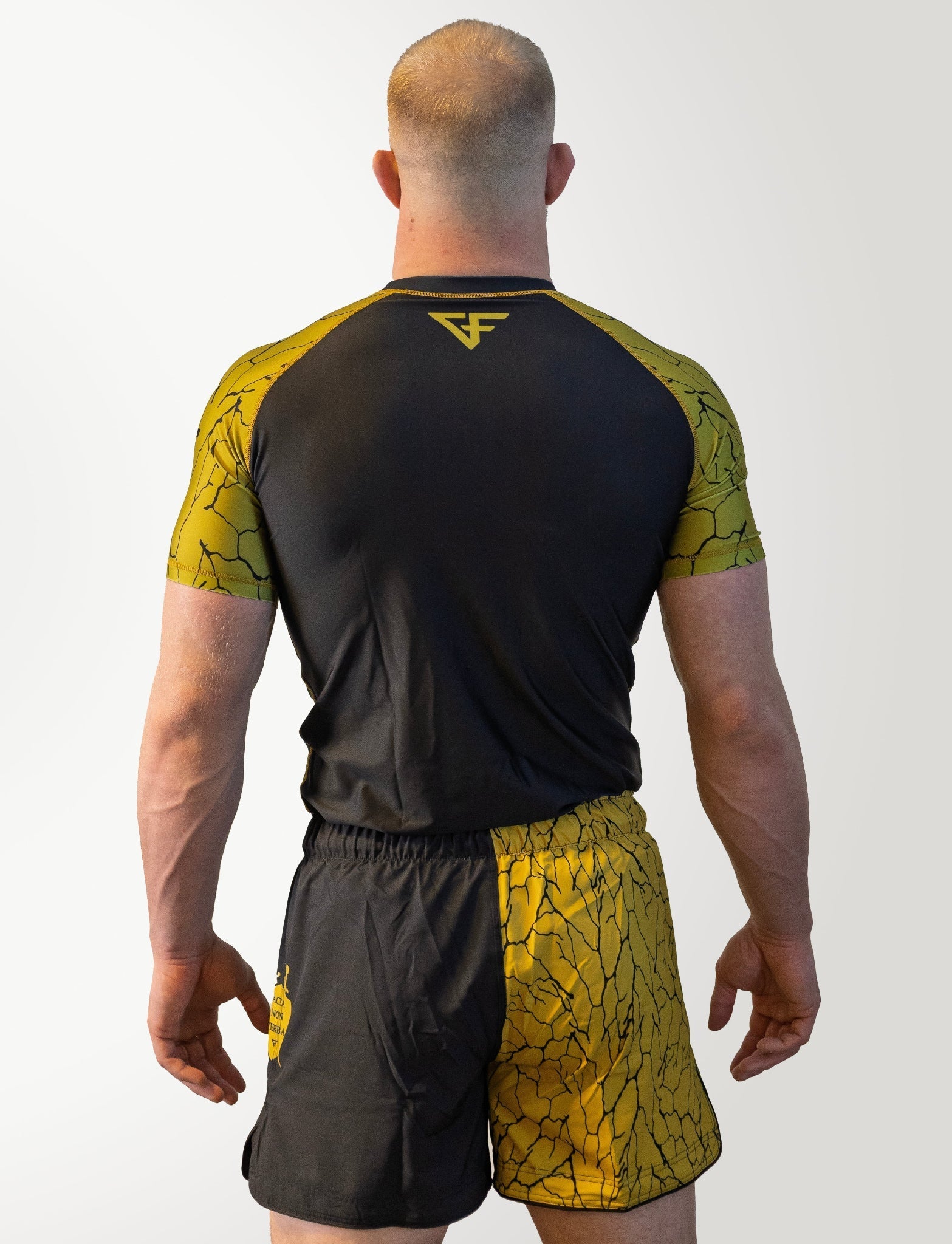 Person wearing black and yellow athletic outfit with a logo on a white background
