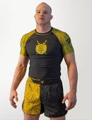 Man wearing a black and yellow athletic outfit with a logo on a white background