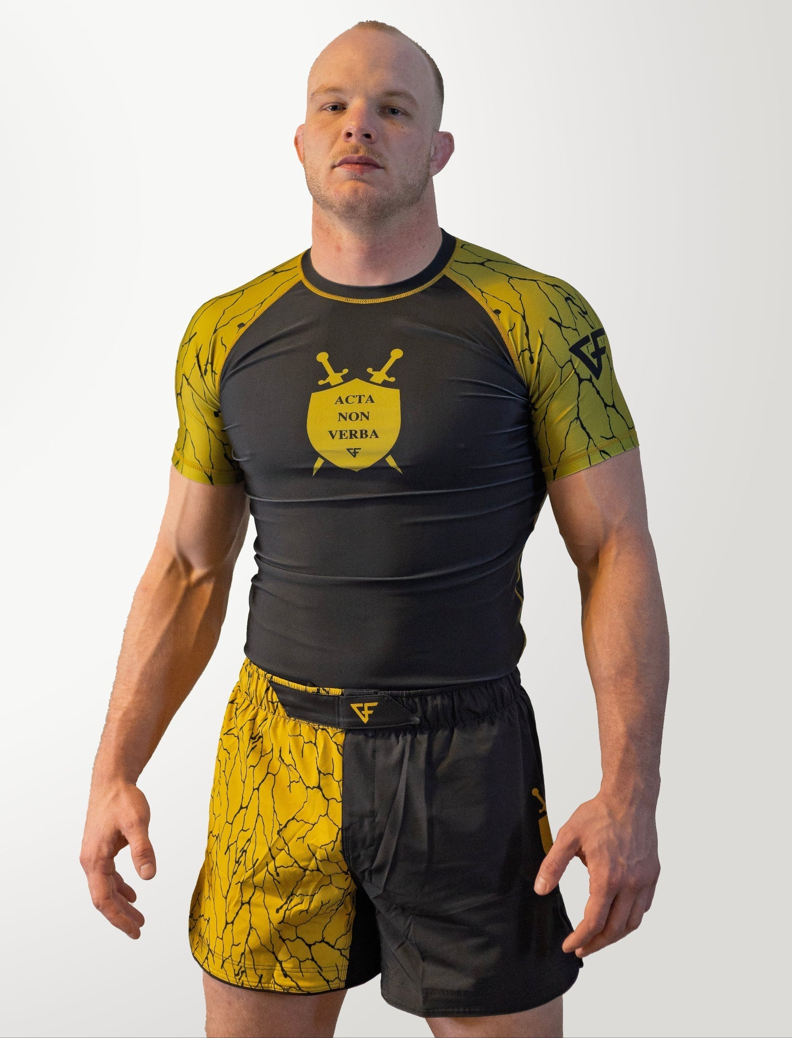 Man wearing a black and yellow athletic outfit with a logo on a white background
