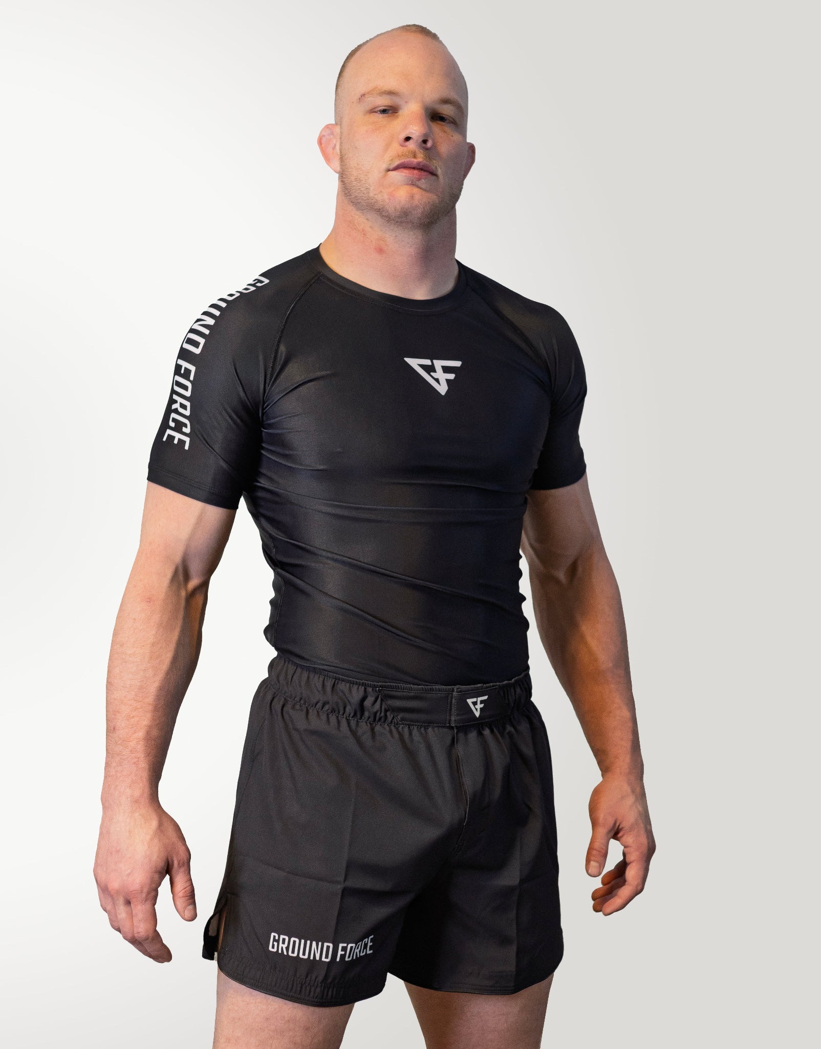 Man wearing a black athletic outfit with 'Ground Force' branding on a white background