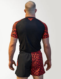 Person wearing a black and red athletic outfit with flame pattern on a white background