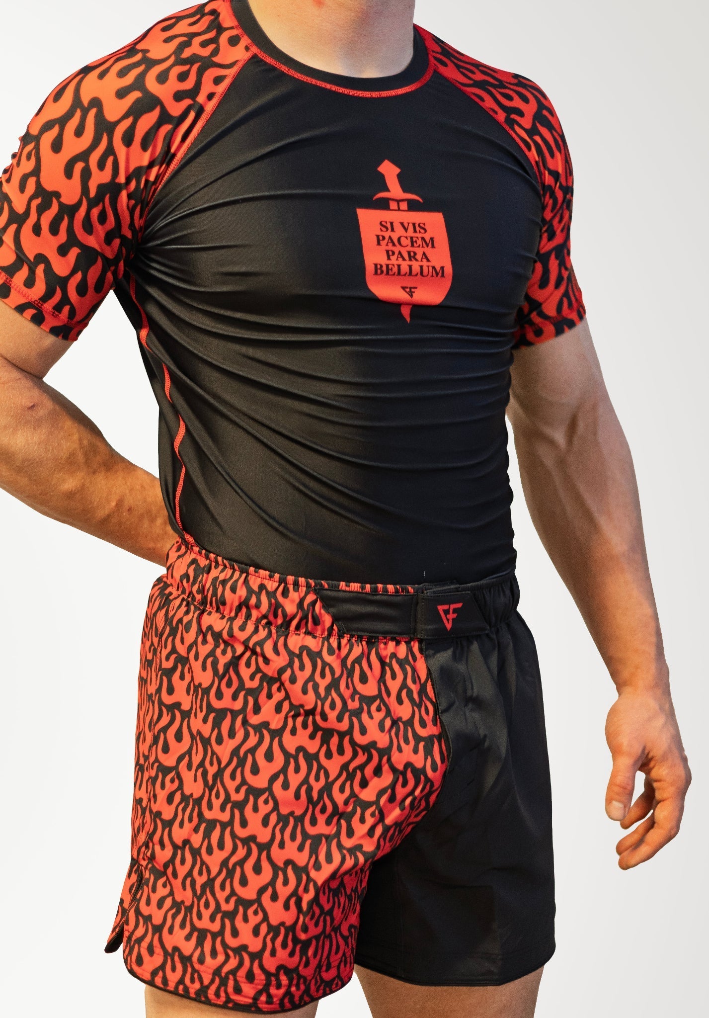 Person wearing a black and red athletic outfit with a logo on a white background
