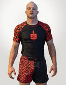 Man wearing a black and red athletic outfit with a logo on a white background